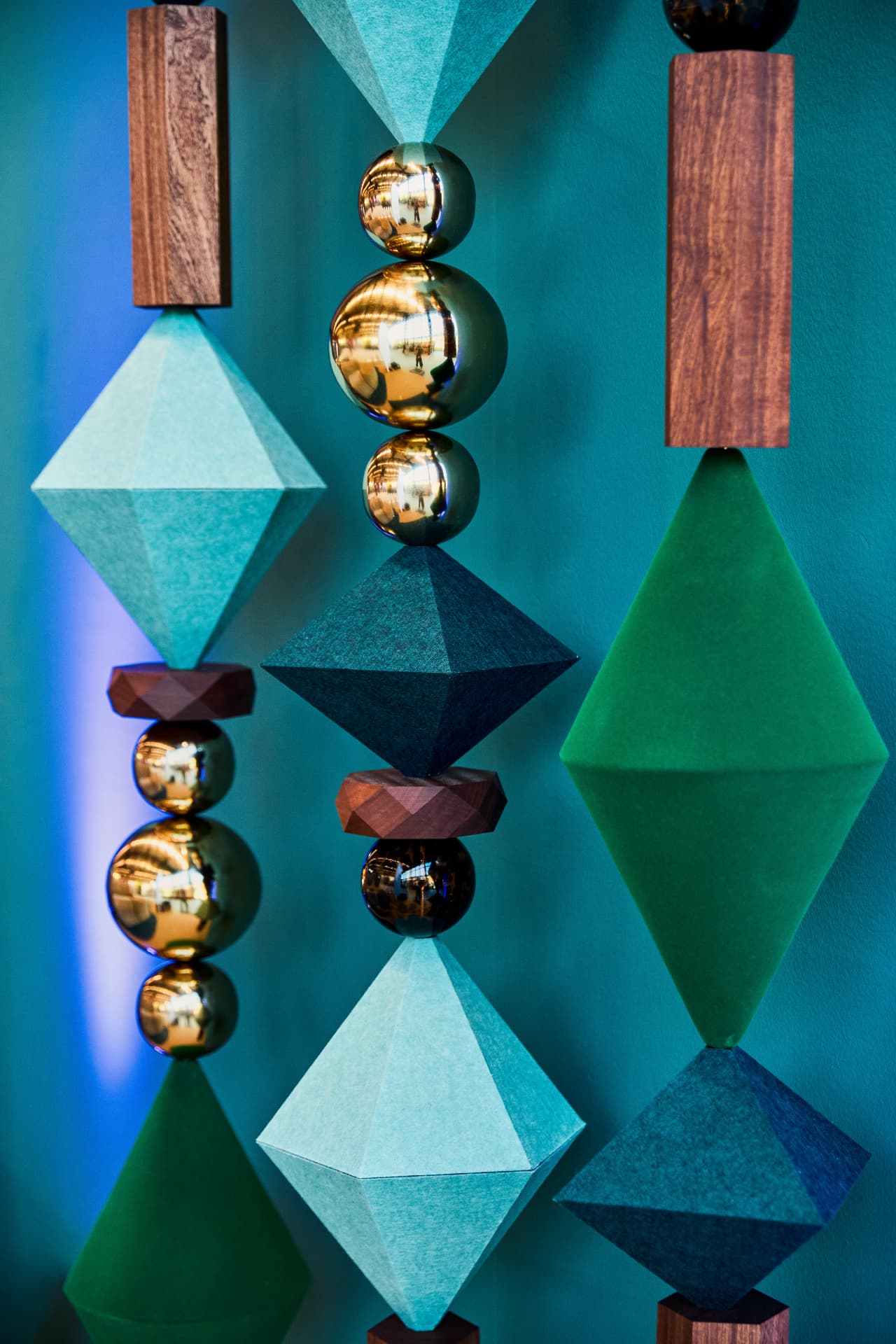 Wood, felt and gold BigBeads strands against a teal wall